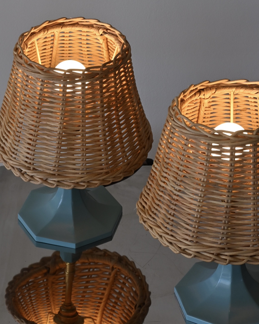 Paire de lampes de chevet en acier laqué bleu azur, laiton et abat-jour en osier tressé